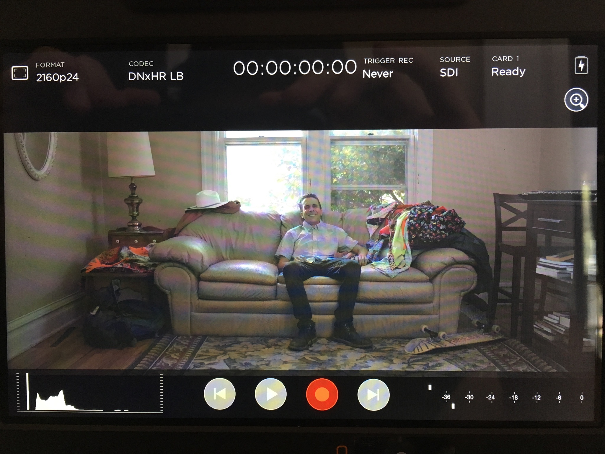 Camera monitor showing person sitting on couch.